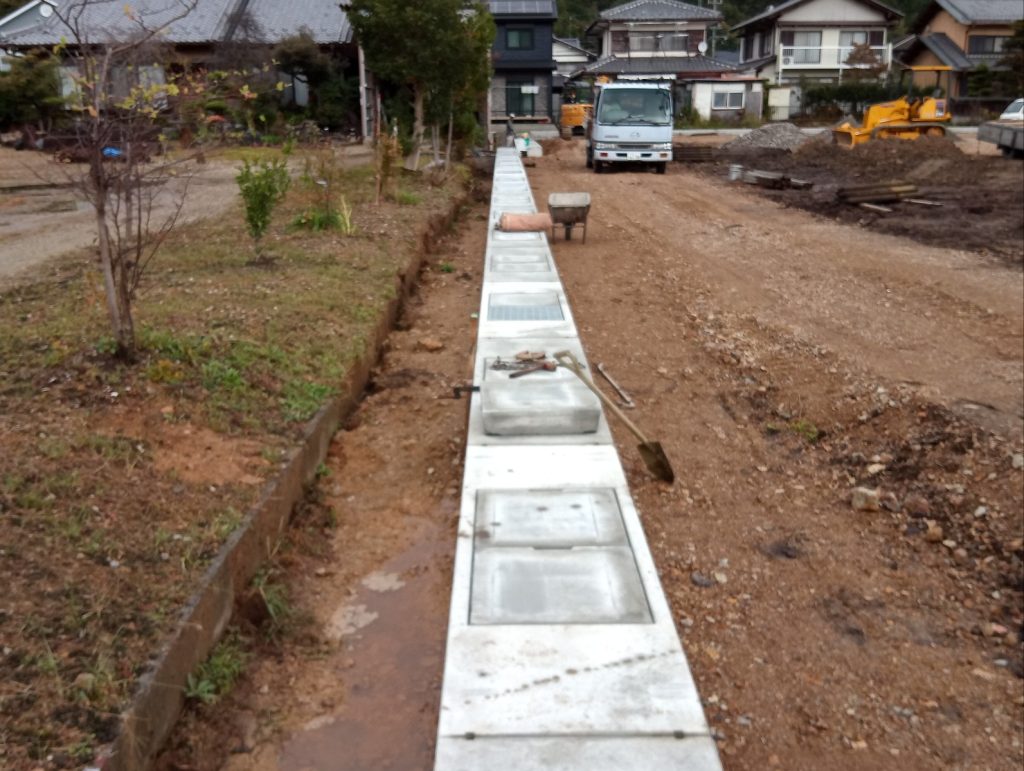 岐阜県岐阜市で建築中の木造老人ホームの可変側溝部埋戻しの柵板撤去の様子